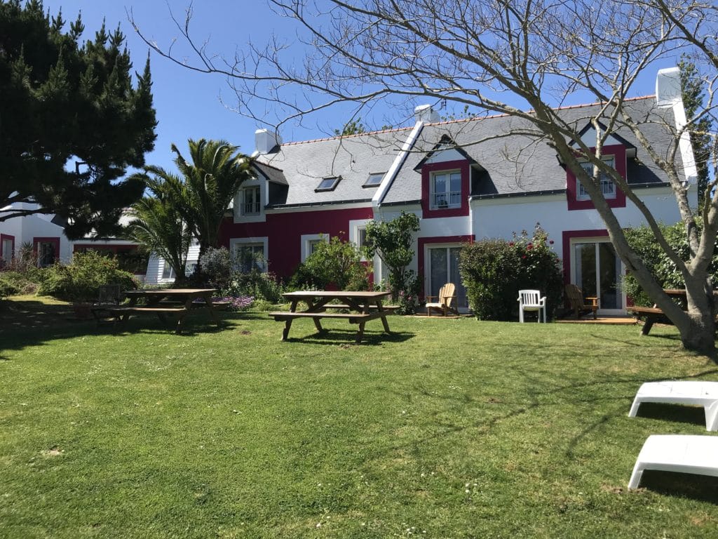 Jardin de l’hôtel Aux Tamaris à Belle-Île avec tables de pique-nique et coin détente
